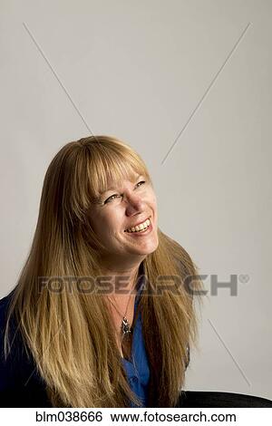 Stock Photograph - Smiling Caucasian woman looking up. Fotosearch
