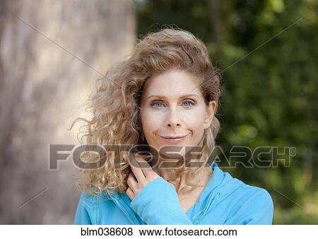 Stock Photo - Smiling Caucasian woman standing outdoors. Fotosearch