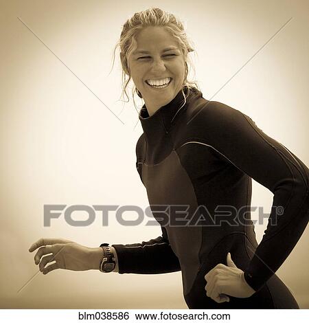 Stock Photograph - Smiling Caucasian woman wearing wetsuit. Fotosearch