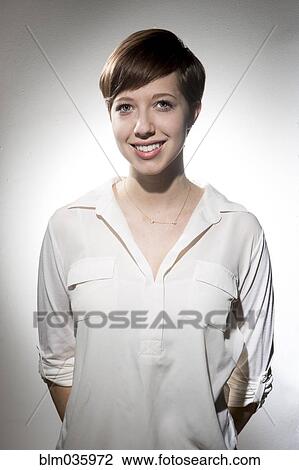 Stock Image - Smiling Caucasian woman wearing white shirt. Fotosearch