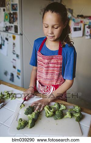 Smiling girl chopping broccoli in kitchen View Large Photo Image Stock Image - Smiling girl chopping broccoli in kitchen. Fotosearch