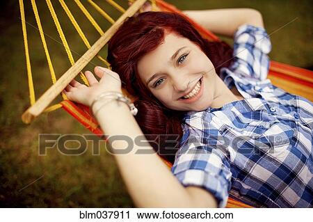 Stock Image - Smiling girl laying in hammock. Fotosearch