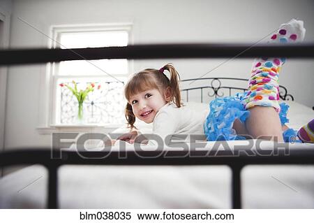 Smiling girl playing on bed View Large Photo Image Stock Photography - Smiling girl playing on bed. Fotosearch