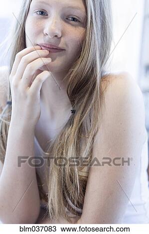 Stock Image - Smiling girl resting chin in hand. Fotosearch