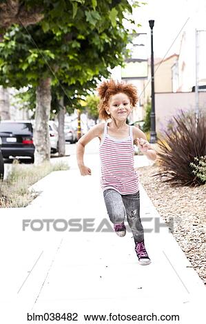 Smiling girl running on city sidewalk View Large Photo Image Stock Image - Smiling girl running on city sidewalk. Fotosearch