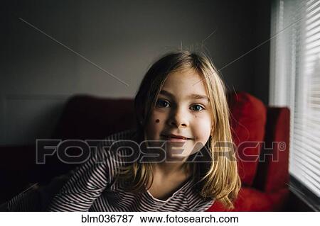 Smiling girl sitting in armchair View Large Photo Image Stock Photo - Smiling girl sitting in armchair. Fotosearch