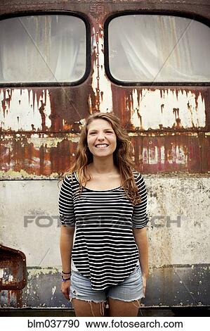 Smiling girl standing near dilapidated bus View Large Photo Image Stock Image - Smiling girl standing near dilapidated bus. Fotosearch