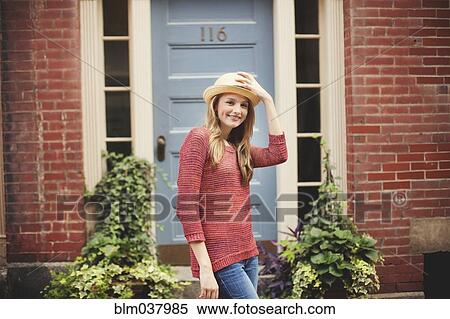 Stock Photography - Smiling girl standing near doorway. Fotosearch