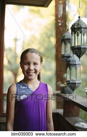 Smiling girl standing on porch View Large Photo Image Stock Image - Smiling girl standing on porch. Fotosearch