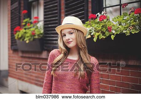 Stock Photograph - Smiling girl standing outside house. Fotosearch