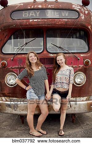 Smiling girls holding hands near dilapidated bus View Large Photo Image Stock Image - Smiling girls holding hands near dilapidated bus. Fotosearch