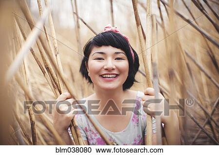 Smiling mixed race woman holding stalks in field View Large Photo Image Stock Image - Smiling mixed race woman holding stalks in field. Fotosearch