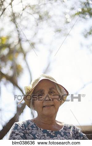 Smiling older woman sitting outdoors View Large Photo Image Stock Photograph - Smiling older woman sitting outdoors. Fotosearch