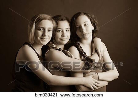 Stock Image - Smiling sisters hugging. Fotosearch