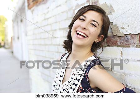 Smiling teenage girl leaning on brick wall View Large Photo Image Stock Photo - Smiling teenage girl leaning on brick wall. Fotosearch