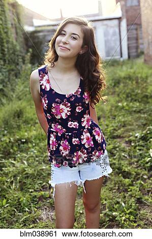 Smiling teenage girl standing in overgrown garden View Large Photo Image Stock Image - Smiling teenage girl standing in overgrown garden. Fotosearch