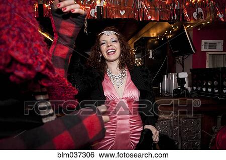 Stock Photograph - Smiling woman cheering in bar. Fotosearch