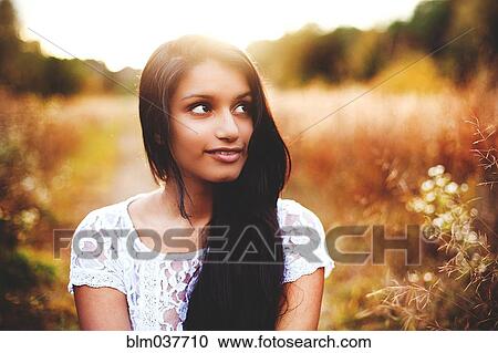 Stock Image - Smiling woman in rural field. Fotosearch