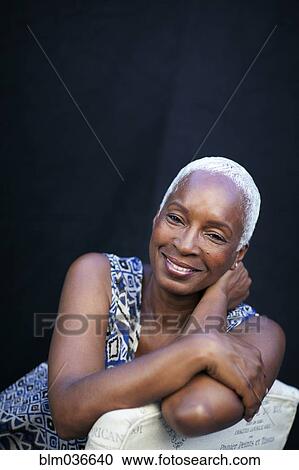 Smiling woman leaning on chair back View Large Photo Image Stock Image - Smiling woman leaning on chair back. Fotosearch