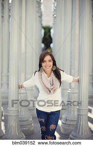 Stock Image - Smiling woman playing in columns. Fotosearch