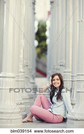 Smiling woman sitting between columns View Large Photo Image Picture - Smiling woman sitting between columns. Fotosearch