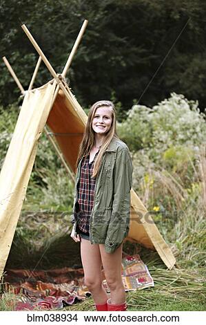 Picture - Smiling woman standing at camping tent. Fotosearch