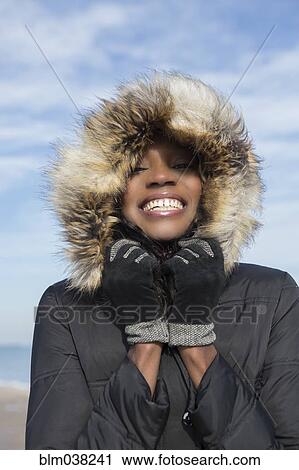 Smiling woman wearing coat on beach View Large Photo Image Stock Image - Smiling woman wearing coat on beach. Fotosearch