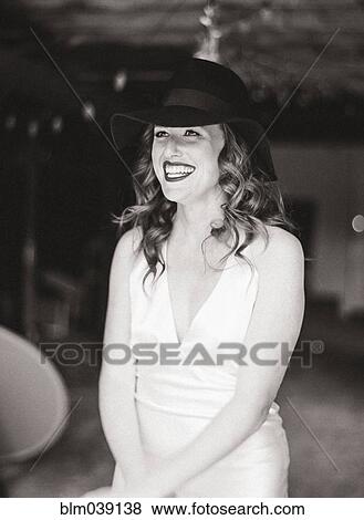 Smiling woman wearing sun hat in backyard View Large Photo Image Stock Photo - Smiling woman wearing sun hat in backyard. Fotosearch