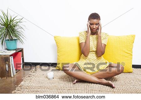 Picture - Stressed Black woman meditating on floor. Fotosearch