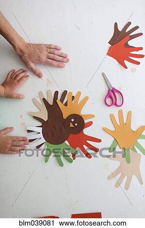 Stock Image - Students and teacher making Thanksgiving turkey crafts in classroom. Fotosearch