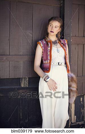 Stock Photo - Stylish woman wearing vest and dress. Fotosearch