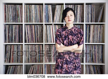 Taiwanese woman standing near record collection View Large Photo Image Stock Photo - Taiwanese woman standing near record collection. Fotosearch