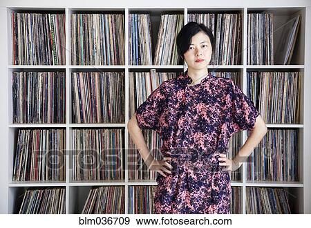 Taiwanese woman standing near record collection View Large Photo Image Stock Photo - Taiwanese woman standing near record collection. Fotosearch