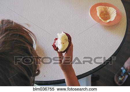 Teenage boy eating cupcake View Large Photo Image Stock Photography - Teenage boy eating cupcake. Fotosearch