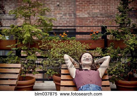 Stock Photography - Teenage girl relaxing on urban rooftop. Fotosearch