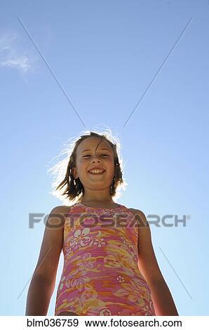 Teenage girl smiling under blue sky View Large Photo Image Stock Photo - Teenage girl smiling under blue sky. Fotosearch