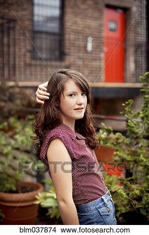 Picture - Teenage girl standing on urban rooftop. Fotosearch