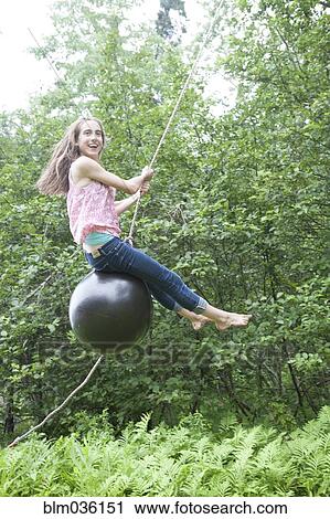 Teenage girl swinging on rope swing View Large Photo Image Stock Image - Teenage girl swinging on rope swing. Fotosearch