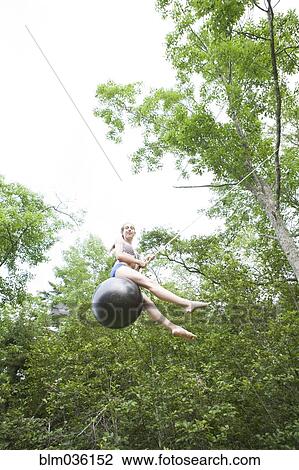 Teenage girl swinging on rope swing View Large Photo Image Stock Image - Teenage girl swinging on rope swing. Fotosearch