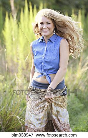 Stock Photo - Teenage girl walking in tall grass. Fotosearch