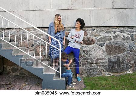 Teenagers and boy standing on steps View Large Photo Image Stock Photography - Teenagers and boy standing on steps. Fotosearch