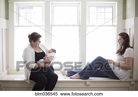 Stock Photography - Three generations of Caucasian women in windowsill. Fotosearch