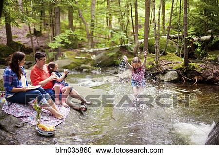 Stock Image - Three generations of Caucasian women playing in river. Fotosearch