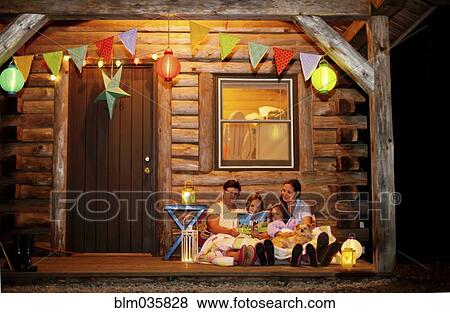 Stock Photo - Three generations of Caucasian women reading on cabin porch. Fotosearch