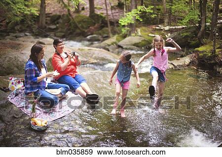 Stock Photo - Three generations of Caucasian women playing in river. Fotosearch