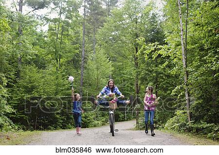 Stock Photograph - Three generations of Caucasian women walking on dirt road. Fotosearch