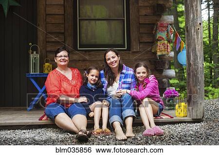 Stock Photograph - Three generations of Caucasian women smiling on cabin porch. Fotosearch