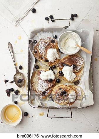 Stock Photograph - Tray of pancakes with fruit and cream. Fotosearch