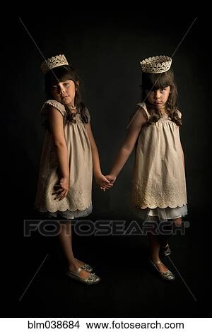 Picture - Twin girls wearing crowns and princess costumes. Fotosearch