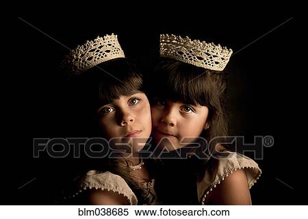 Stock Photography - Twin girls wearing crowns and princess costumes. Fotosearch